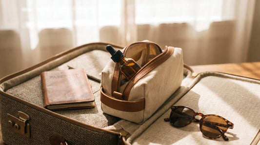 Flacon d'huile de CBD dans une trousse de toilette posée sur une valise avec un passeport