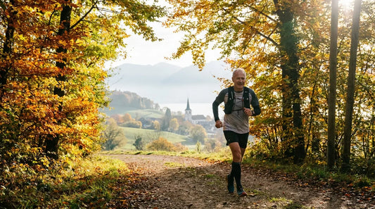 Un joggeur sur un chemin bordé d'arbres aux couleurs automnales