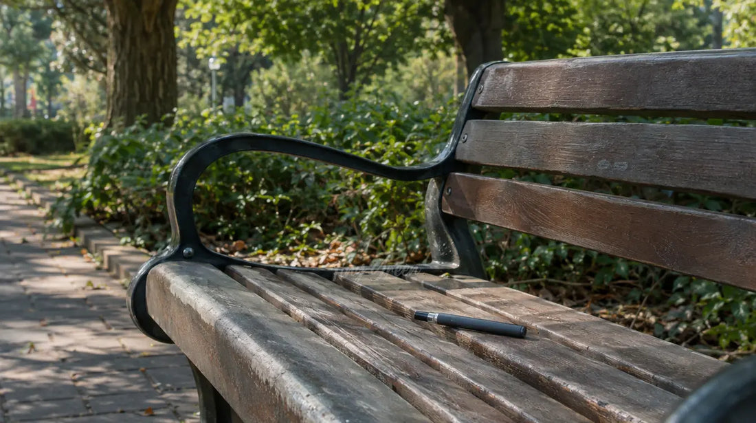 Banc de parc vide en plein jour avec une petite vape discrète posée dessus