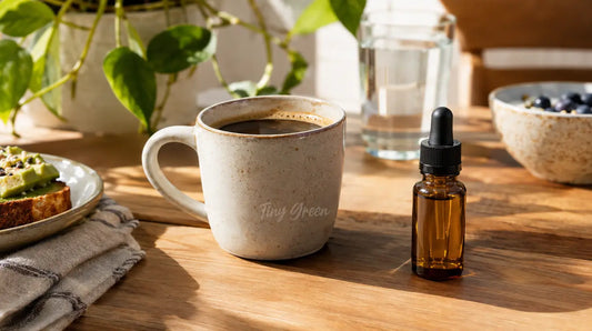 Table de petit-déjeuner avec une tasse de café et un petit flacon compte-gouttes de CBD